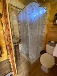 a bathroom with a toilet in a wooden cabin at El Refugio del Santo 