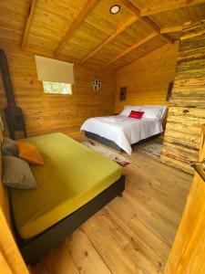 a bedroom with a bed in a wooden cabin at El Refugio del Santo in El Lindero