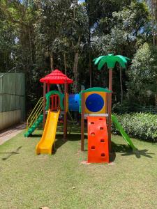 a playground with colorful play equipment on the grass at Condomínio VISTA AZUL in Domingos Martins