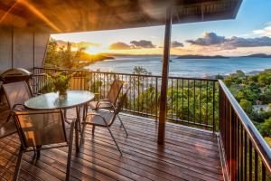 a balcony with a table and chairs and a view of the ocean at Panorama Apartments on Hamilton Island by HIHA in Hamilton Island