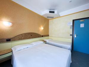 リミニにあるHotel Solebluのベッド2台と青いドアが備わる客室です。