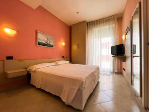 リミニにあるHotel Solebluのオレンジ色の壁のベッドルーム1室(ベッド1台付)