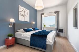 een slaapkamer met een bed met blauwe muren en een raam bij Apartments with a parking space Rabac, Labin - 9670 in Rabac