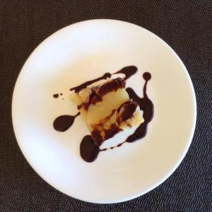 a white plate with a piece of cake and chocolate sauce at Elnido Terra Nova beach resort Sunset Villa in El Nido