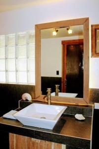 a bathroom with a sink and a large mirror at Elnido Terra Nova beach resort Sunset Villa in El Nido
