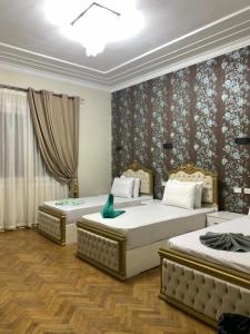 Lucky Hostel في القاهرة: سريرين في غرفة فندق يوجد عليها طير أخضر