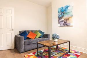 ein Wohnzimmer mit einem Sofa und einem Tisch in der Unterkunft 3-bedroom Home in Liverpool L15 with FREE Parking in Liverpool