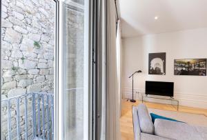 a living room with a stone wall and a couch at Citybreak-apartments Patio in Porto