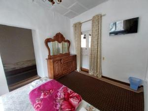 a bedroom with a bed and a mirror and a window at Fayz Guest House in Samarkand