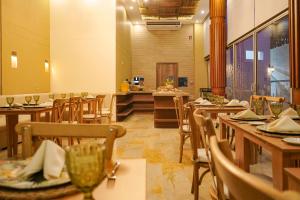 聖瑪爾塔的住宿－HOTEL KARAYA DIVE RESORT，餐厅设有木桌、椅子和柜台