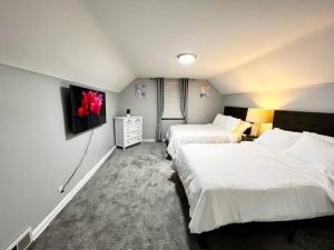 Habitación de hotel con 2 camas y TV en Stylish Cape Cod Cutie All Queen Beds 13 Min to downtown, en Cincinnati