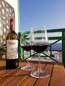 a bottle of wine and two glasses on a table at Great Ocean View and Lobos & Fuerteventura Islands in Tías