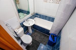 a bathroom with a toilet and a sink and a bath tub at 1 комнатная квартира в центре на Пушкина 92 in Kostanay