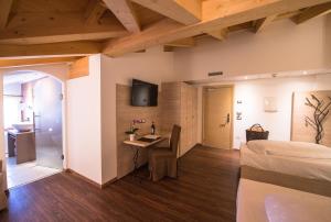 1 dormitorio con 1 cama y escritorio en una habitación en Golden Park Resort en Campitello di Fassa