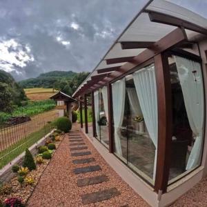 ein kleines Haus mit Glastüren und einer Terrasse in der Unterkunft Cantinho Paz e Amor in Nova Petrópolis