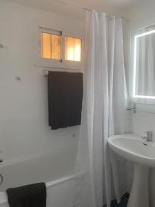 een badkamer met een wit douchegordijn en een wastafel bij Benalmadena Jupiter Ocean View Apartament in Benalmádena