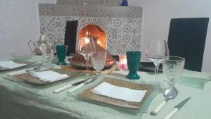 une table avec des assiettes, des verres et une lampe dans l'établissement Hostel artistic airport, à Marrakech