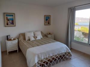 una camera da letto con un letto e una grande finestra di El Mirador de los Manantiales a Villa Parque Síquiman