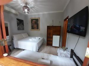 uma sala de estar com 2 camas e uma televisão de ecrã plano em Pousada Numei de Jeri em Jericoacoara