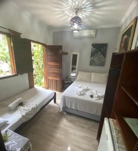 um quarto com 2 camas, um sofá e uma janela em Pousada Numei de Jeri em Jericoacoara