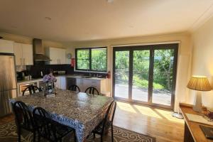 カトゥーンバにあるNarrow Neck Views - Peaceful 4 Bedroom Home with Stunning Views!のキッチン(テーブル、椅子付)、大きな窓が備わります。