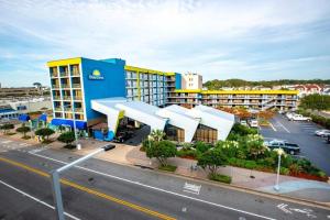 un hotel con un edificio azul y amarillo en una calle en Days Inn by Wyndham Virginia Beach At The Beach en Virginia Beach