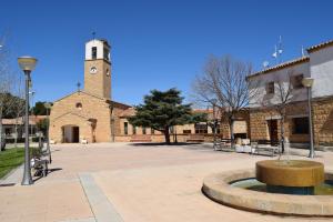 un edificio con una torre de reloj y una fuente en Casa Rural Natalia, en Valmuel