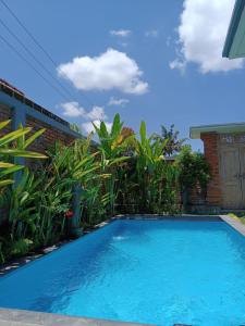 une piscine bleue en face d'une maison dans l'établissement Ubud Mayura Private Pool Villa, à Ubud