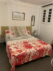 Schlafzimmer mit einem Bett mit einer roten und weißen Bettdecke in der Unterkunft Bas de villa cosy in Le Lamentin