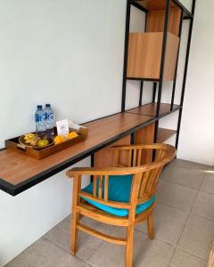 a wooden desk with a chair and a plate of fruit at The Palms Canggu in Canggu