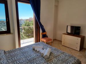 ein Schlafzimmer mit einem Bett mit Handtüchern und einem Fenster in der Unterkunft Via Pasquale Testa in Formia