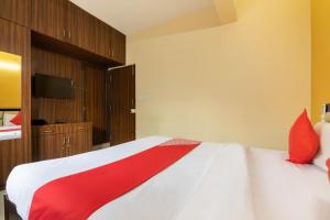 een slaapkamer met een bed met een rode deken erop bij OYO Hotel Royal INN Near Nexus Mall Koramangala in Bangalore