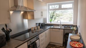 una pequeña cocina con fregadero y ventana en Reedley House en Nelson