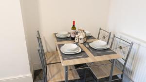 - une table avec des assiettes et une bouteille de vin dans l'établissement Reedley House, à Nelson