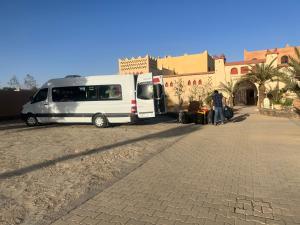 a white van parked in front of a building at Enjoy Moda Camp Merzouga tours- Camel sunset sunrise Quad Sunboarding ATV in Merzouga