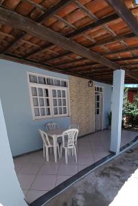 a patio with chairs and a table and a roof at Praia de Guaibim - Casa de praia 2Q - 2 suítes com ar - em condomínio a 300m da praia in Guaibim