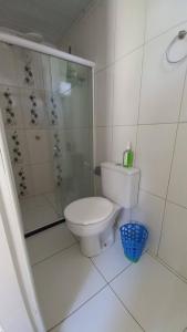 biała łazienka z toaletą i prysznicem w obiekcie Praia de Guaibim - Casa de praia 2Q - 2 suítes com ar - em condomínio a 300m da praia w mieście Guaibim
