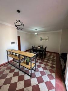 a living room with two tables and a checkered floor at Magnolia II Departamento Céntrico in San Fernando del Valle de Catamarca