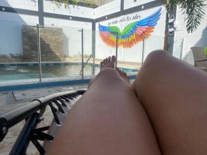 a woman laying on a hammock near a swimming pool at Hospedaje Mi Fortaleza, Con Piscina, Parqueadero y estamos a 10 Minutos Caminando a Playa Dormida, 5 Minutos del Aeropuerto y a 15 Del Rodadero en Bus in Santa Marta