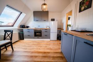 eine Küche mit einem weißen Kühlschrank und Holzböden in der Unterkunft STYLE-Apartment I Klimaanlage I WLAN I Küche I Smart-TV in Magdeburg
