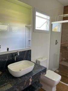 a bathroom with a sink and a toilet and a window at Bella Pousada in Pomerode