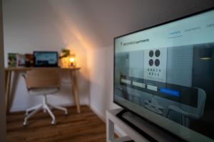 ein Wohnzimmer mit einem Flachbild-TV und einem Stuhl in der Unterkunft STYLE-Apartment I Klimaanlage I WLAN I Küche I Smart-TV in Magdeburg