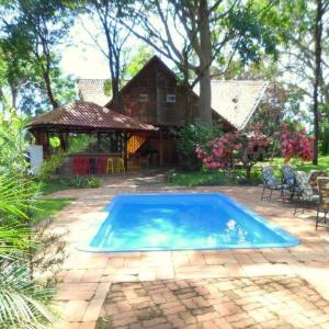 een blauw zwembad voor een huis bij Vila Chale in Bauru