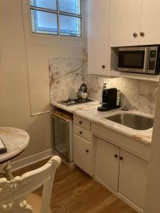 a kitchen with a sink and a microwave at Pineapple House, Cozy Garden Apartment, City Center! Marble-Tiled Bathroom! FREE parking! in Denver