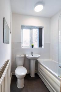 a white bathroom with a toilet and a sink at Family & Contractors & Free Parking & Airport Location in Doncaster