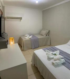a hotel room with two beds and a television at Pousada Barreirinhas House in Barreirinhas