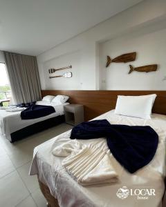 pokój hotelowy z dwoma łóżkami i ręcznikami na nich w obiekcie Eco Resort Praia dos Carneiros - Flats & Bangalô - LocarHouse w mieście Praia dos Carneiros +274 zdjęcia