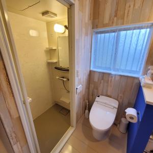 een kleine badkamer met een toilet en een raam bij 満天の庭 Manten-no-niwa in Kurume