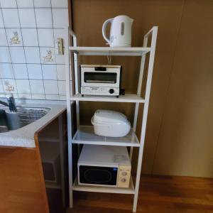 a kitchen shelf with a microwave and a toaster oven at 満天の庭 Manten-no-niwa in Kurume