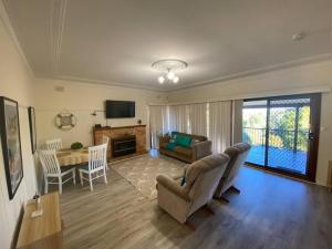 a living room with a couch and a table at Boyle's Beach House - Fully furnished 3 Bedroom home. Secure parking. in Nambucca Heads